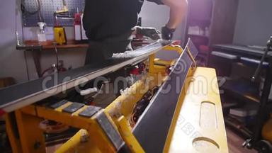 滑雪板保养维修理念.. 车间工人正在打蜡和修理滑雪板和滑雪板